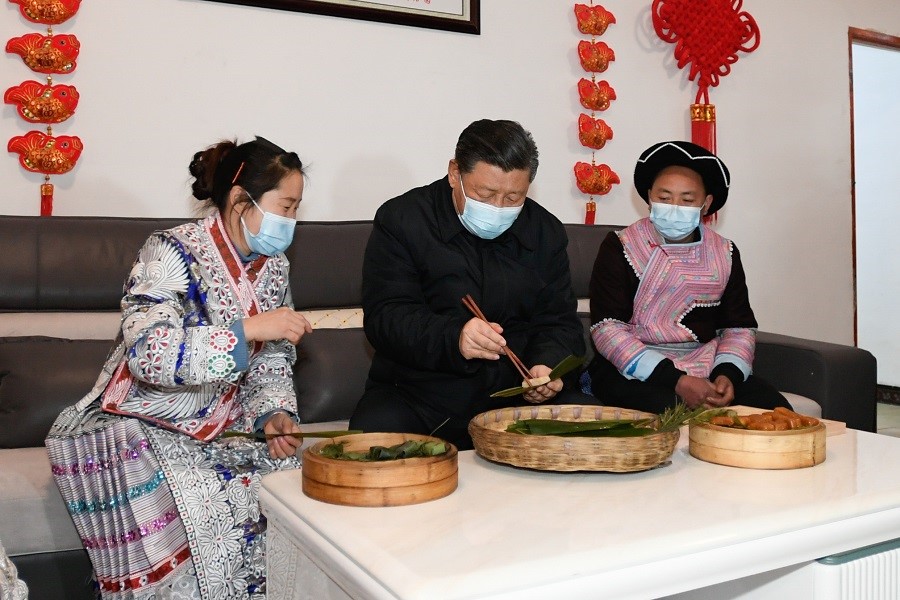 2021年2月3日下午，習(xí)近平在貴州畢節(jié)市黔西縣新仁苗族鄉(xiāng)化屋村苗族村民趙玉學(xué)家，同一家人邊聊家常邊制作當(dāng)?shù)貍鹘y(tǒng)節(jié)日食品黃粑。新華社記者 李學(xué)仁 攝